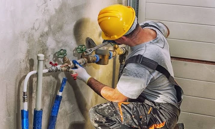 Plumber installing a shutoff valve on an exterior line at a Fremont, CA home